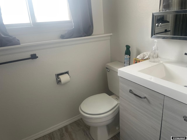 bathroom with hardwood / wood-style floors, vanity, and toilet