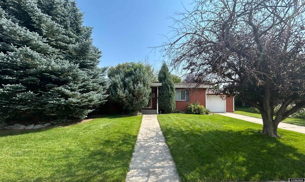 view of front of house with a garage and a front lawn