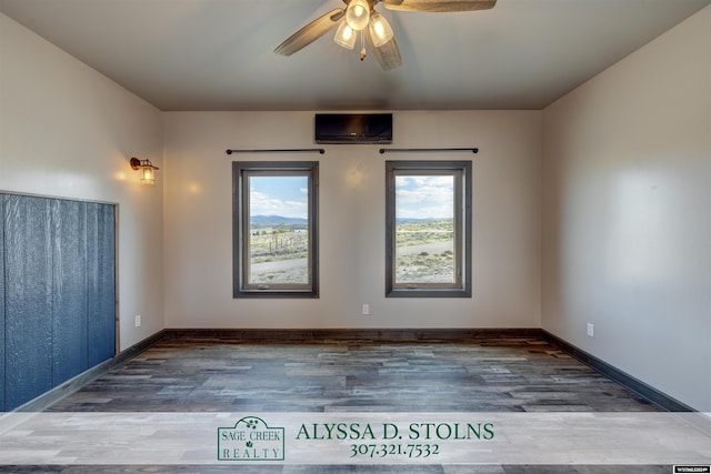 spare room with wood finished floors, a ceiling fan, and baseboards