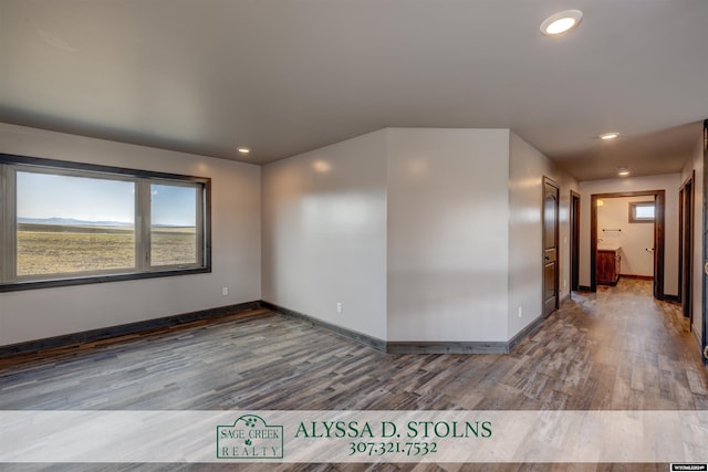 spare room featuring recessed lighting, wood finished floors, and baseboards