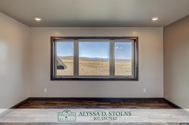 spare room featuring baseboards, wood finished floors, and recessed lighting