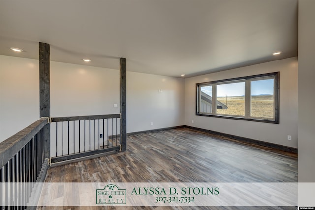 empty room featuring baseboards, wood finished floors, and recessed lighting