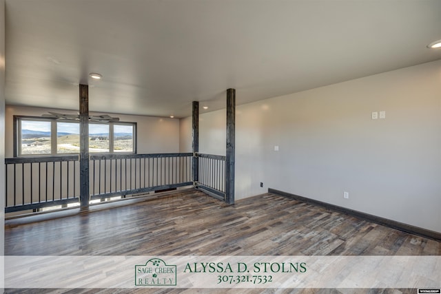 spare room featuring wood finished floors and baseboards