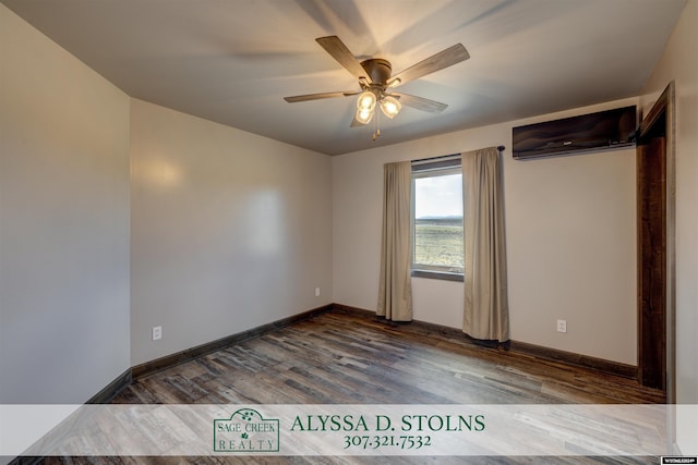 empty room with a ceiling fan, dark wood-style flooring, a wall unit AC, and baseboards