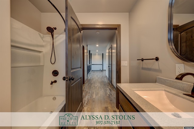 bathroom with  shower combination, wood finished floors, and vanity