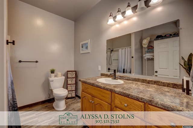 bathroom featuring vanity, toilet, wood-type flooring, walk in shower, and vaulted ceiling