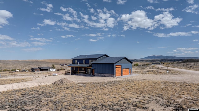 view of front of home with a garage, a sunroom, and a mountain view