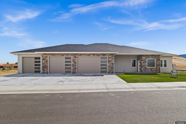 view of front of property featuring a garage and a front lawn