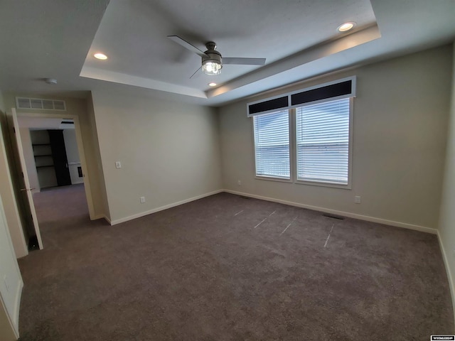 spare room featuring ceiling fan, carpet, and a tray ceiling