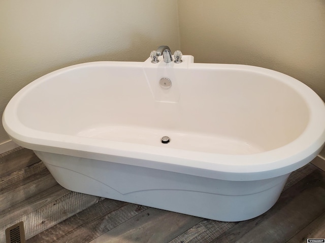 room details featuring a bath and hardwood / wood-style flooring