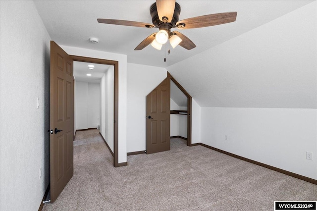 additional living space with ceiling fan, light carpet, and lofted ceiling