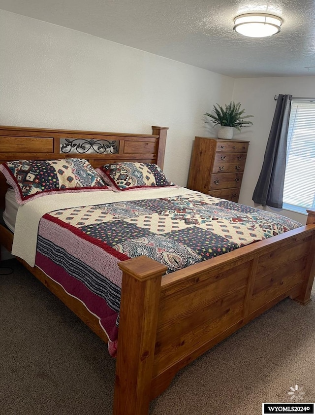 bedroom with a textured ceiling and carpet floors