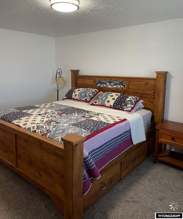 bedroom with a textured ceiling and carpet flooring