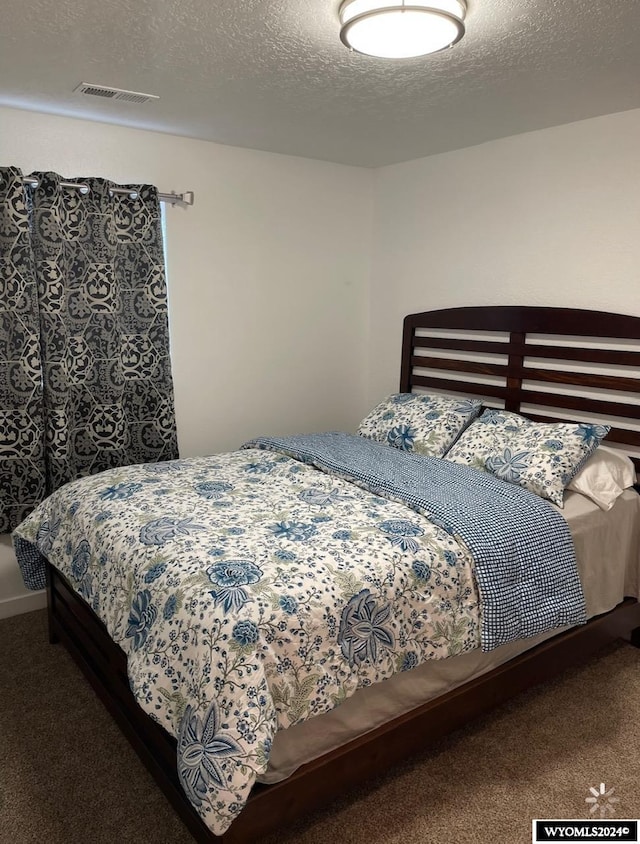 bedroom featuring carpet and a textured ceiling