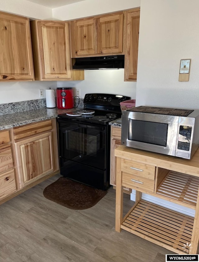 kitchen featuring hardwood / wood-style flooring, stone countertops, range hood, and black range with electric cooktop