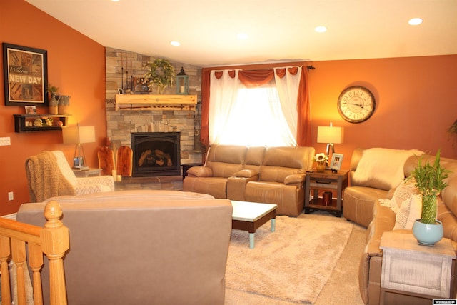 carpeted living room with lofted ceiling and a stone fireplace