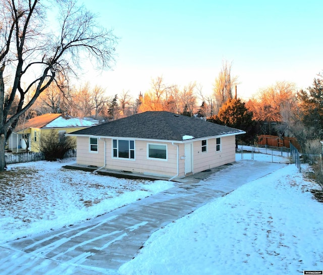 view of front of house with roof with shingles and fence