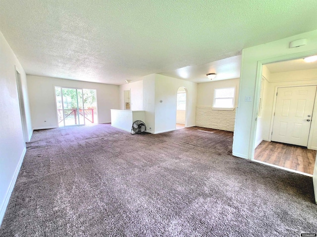 unfurnished living room with a textured ceiling and carpet floors