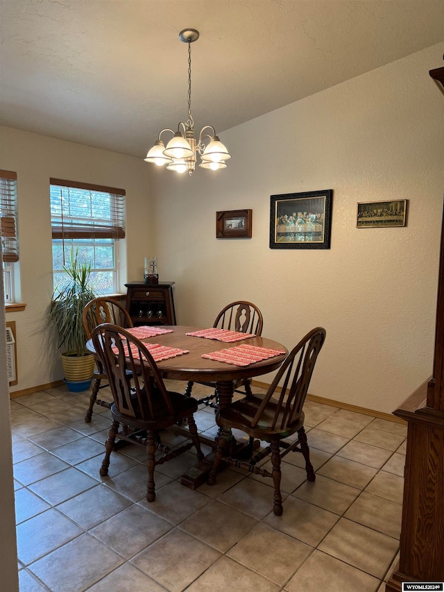 dining space with light tile patterned flooring and a notable chandelier