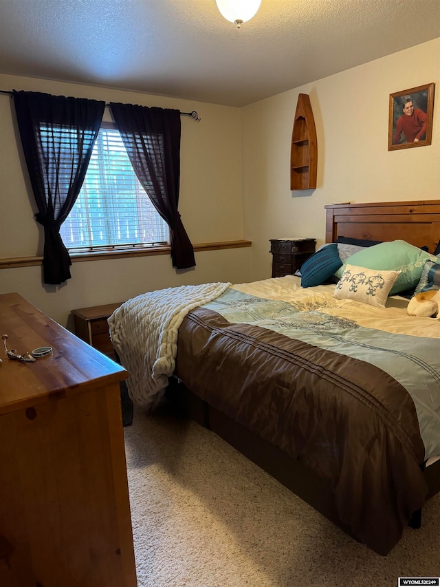 carpeted bedroom featuring a textured ceiling