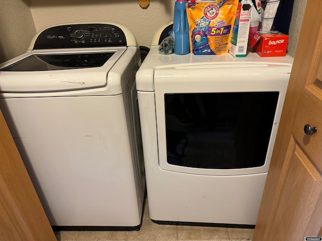 laundry area featuring light tile patterned flooring and washer and clothes dryer