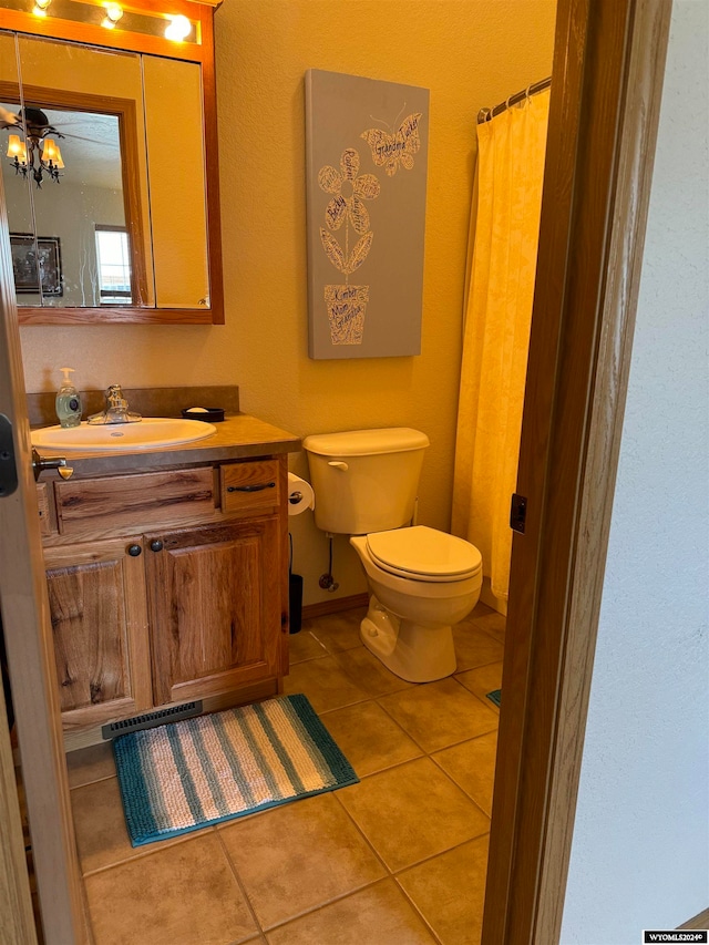 bathroom featuring ceiling fan, toilet, vanity, and tile patterned floors