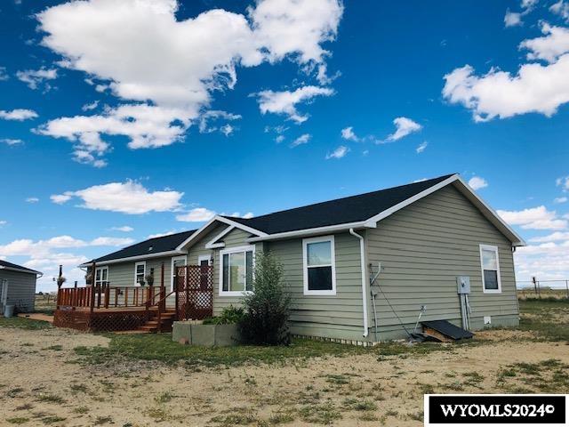 rear view of property featuring a wooden deck