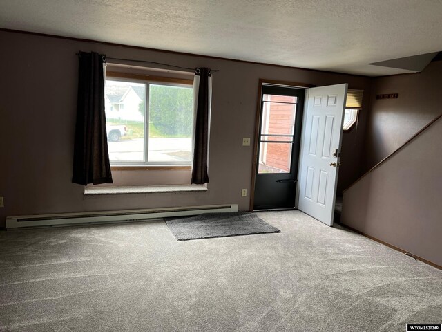 entrance foyer with carpet flooring, a textured ceiling, and a baseboard heating unit