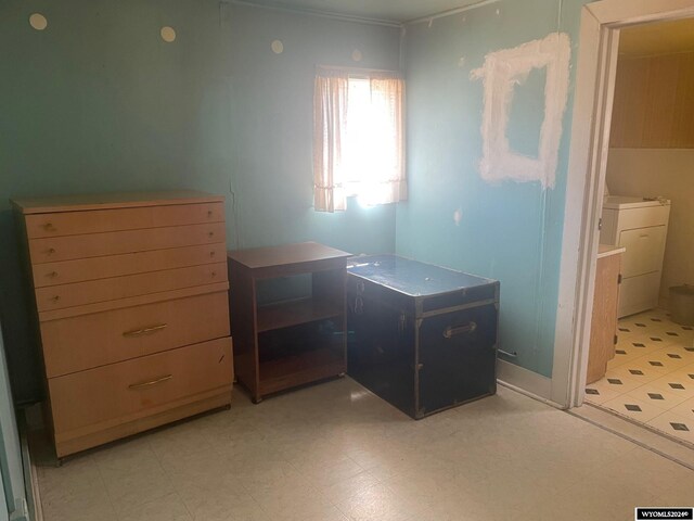 bedroom with washer / clothes dryer and light tile patterned flooring