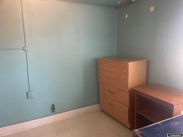 bedroom with light floors and baseboards