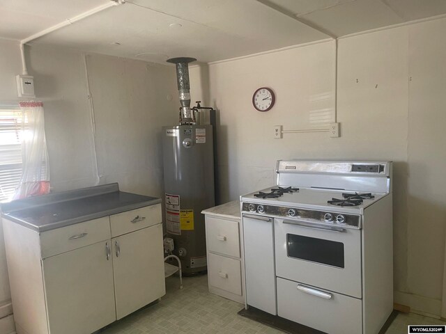 kitchen with water heater, white cabinets, range with two ovens, and light tile patterned floors