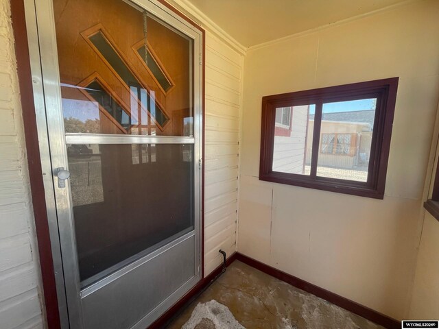 doorway to outside featuring crown molding