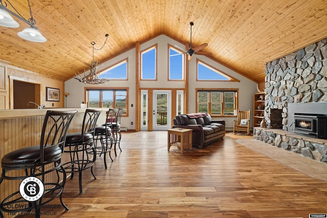 living room with light wood-type flooring, high vaulted ceiling, a fireplace, and wooden ceiling