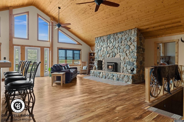 living room with high vaulted ceiling, ceiling fan, light hardwood / wood-style floors, and wooden ceiling