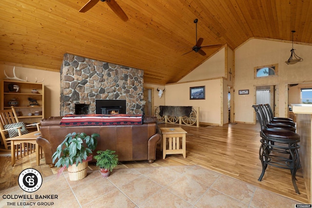 living room with wood ceiling, ceiling fan, vaulted ceiling, and a fireplace