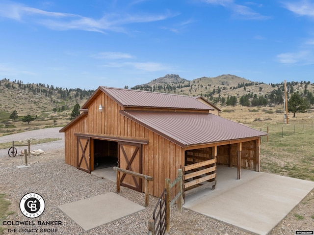 view of front of property with a mountain view and an outdoor structure