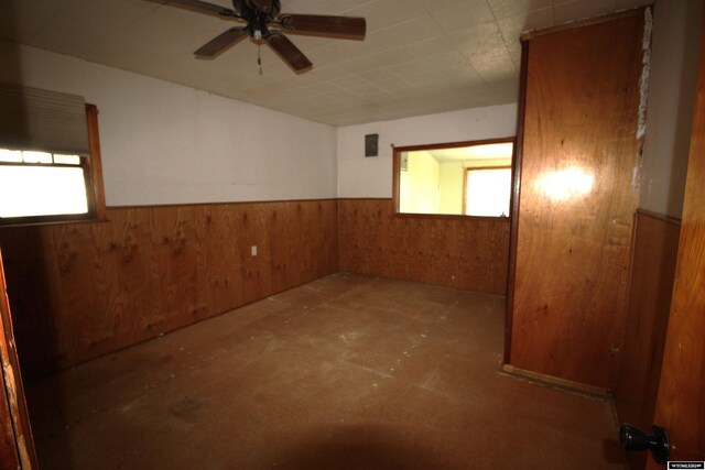 213 10th Ave, Lyman, NE 69352 - unfurnished room with wood walls, a ceiling fan, and wainscoting