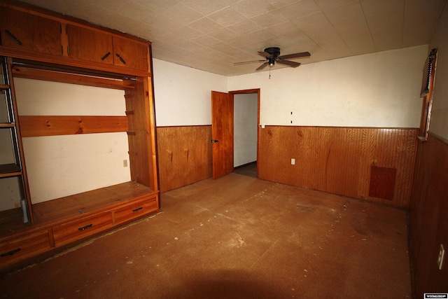 213 10th Ave, Lyman, NE 69352 - unfurnished bedroom with wainscoting, concrete flooring, and wood walls