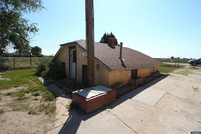 213 10th Ave, Lyman, NE 69352 - view of side of home with fence, roof with shingles, and stucco siding