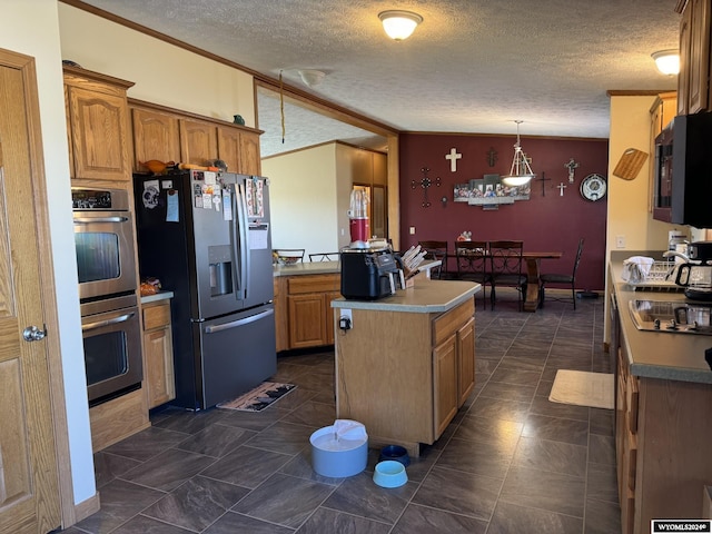 kitchen featuring a center island, crown molding, lofted ceiling, brown cabinetry, and black appliances