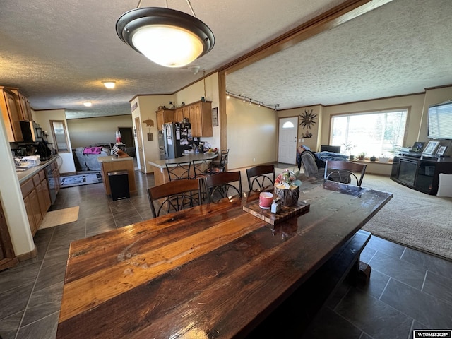 dining space with dark carpet, a textured ceiling, dark tile patterned floors, and crown molding