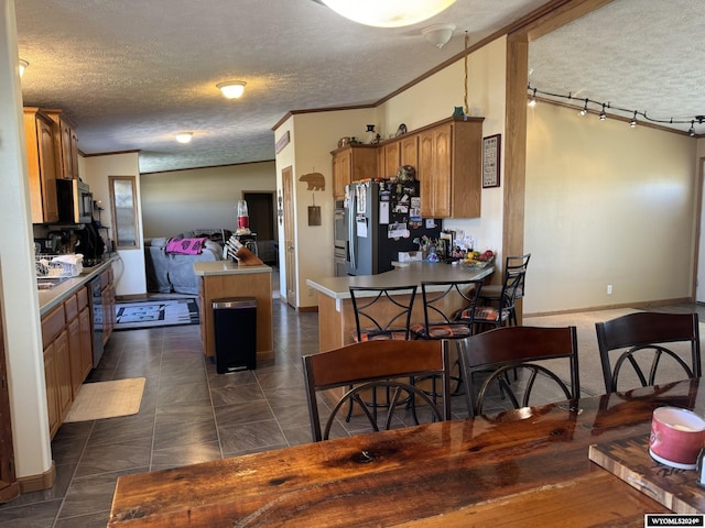 kitchen featuring ornamental molding, a kitchen island, a textured ceiling, brown cabinetry, and stainless steel fridge with ice dispenser