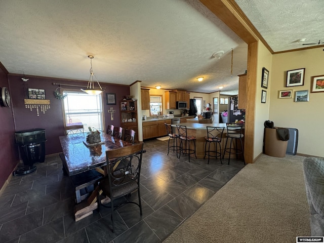 dining room with a textured ceiling, crown molding, and baseboards