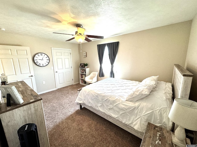 carpeted bedroom featuring ceiling fan and a textured ceiling