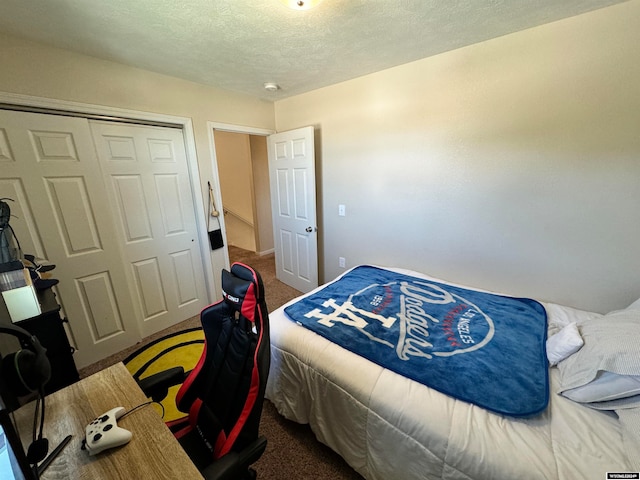 bedroom featuring a textured ceiling, carpet, and a closet