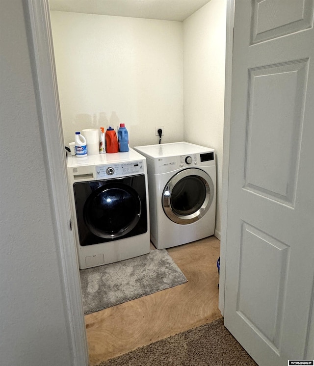 washroom with separate washer and dryer and light colored carpet