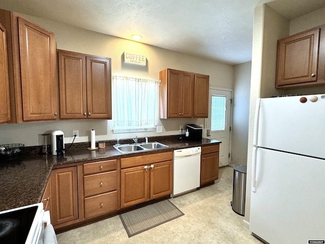 kitchen featuring white appliances, a textured ceiling, and sink