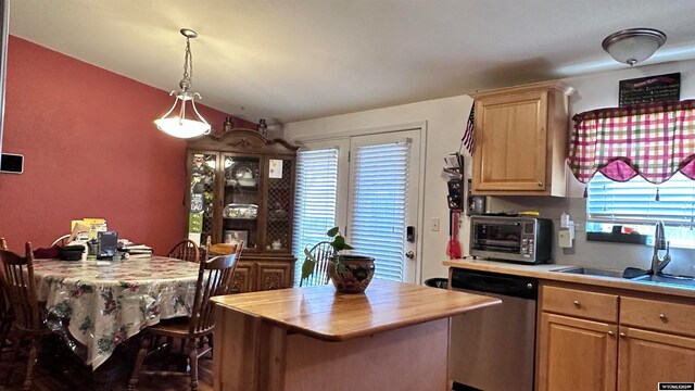 kitchen with a kitchen bar, dishwasher, a kitchen island, and a healthy amount of sunlight