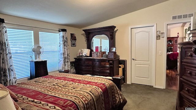 bedroom featuring lofted ceiling and dark carpet