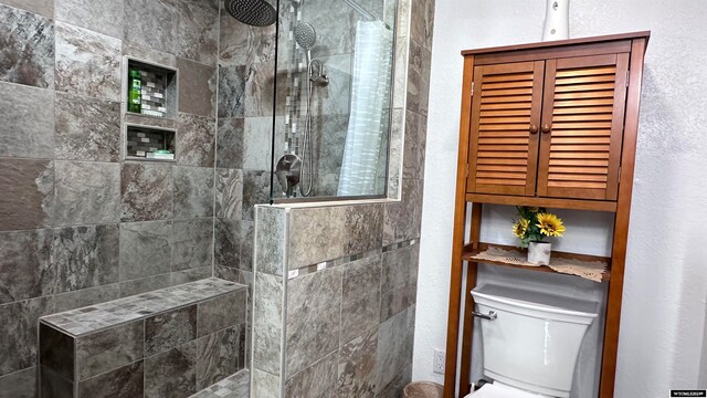 bathroom featuring tiled shower and toilet